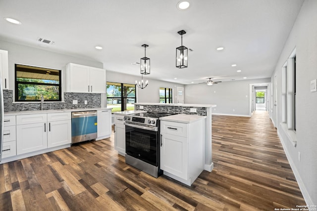 kitchen featuring appliances with stainless steel finishes, dark hardwood / wood-style flooring, ceiling fan with notable chandelier, decorative light fixtures, and white cabinets