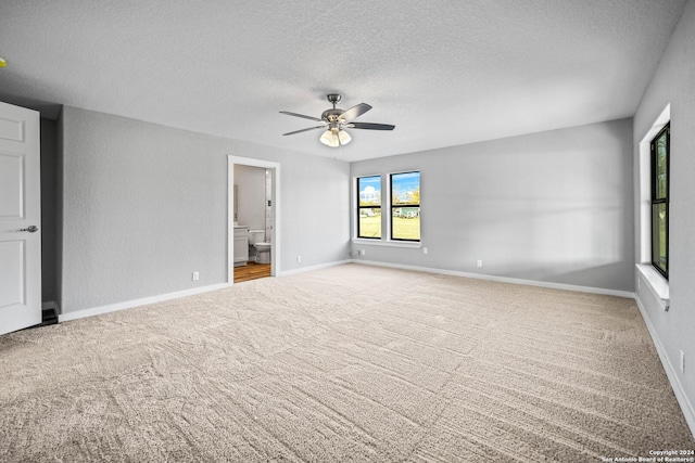 carpeted empty room with a textured ceiling and ceiling fan