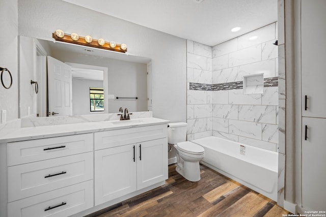 full bathroom with vanity, toilet, wood-type flooring, and tiled shower / bath