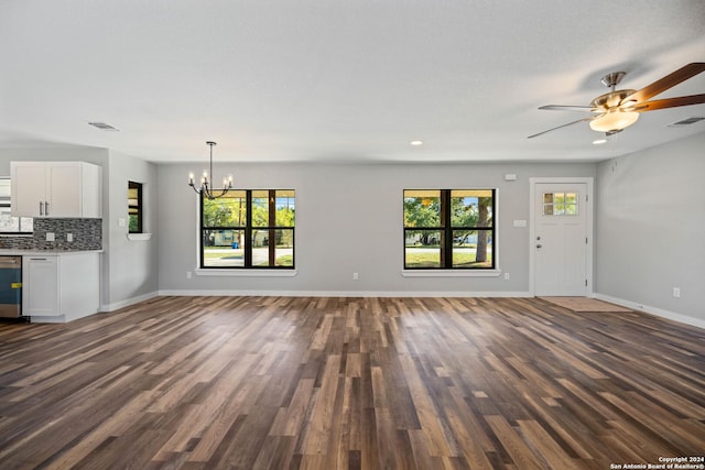 unfurnished living room featuring ceiling fan with notable chandelier and dark wood-type flooring