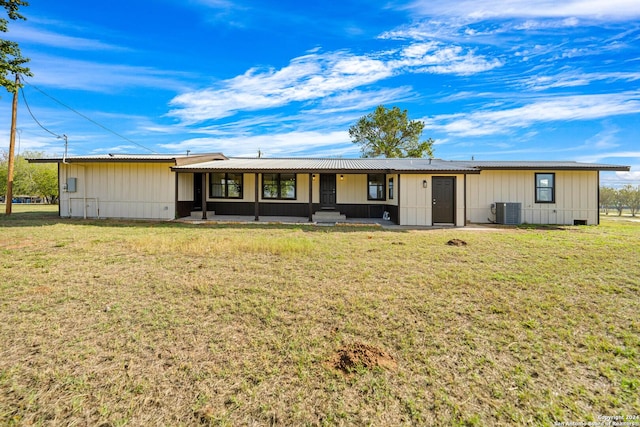 view of front of house with central AC unit and a front yard