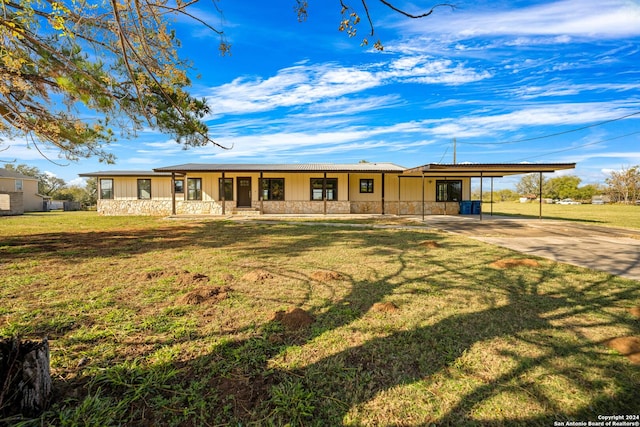 rear view of house with a lawn, a porch, and a carport