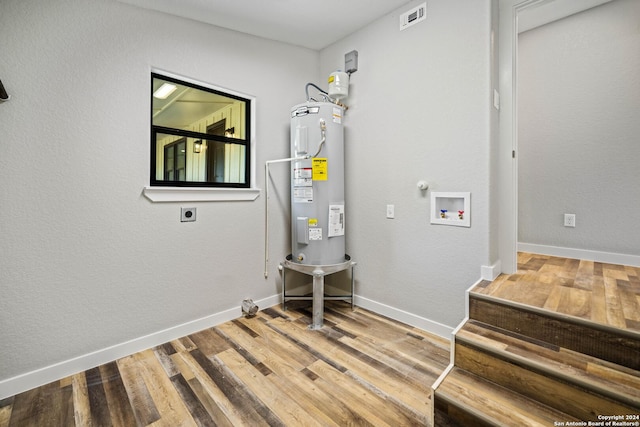 laundry room with hookup for a washing machine, water heater, hardwood / wood-style floors, and hookup for an electric dryer