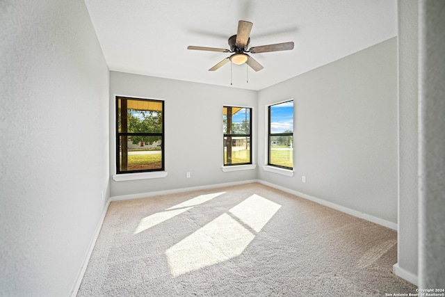 carpeted spare room featuring ceiling fan