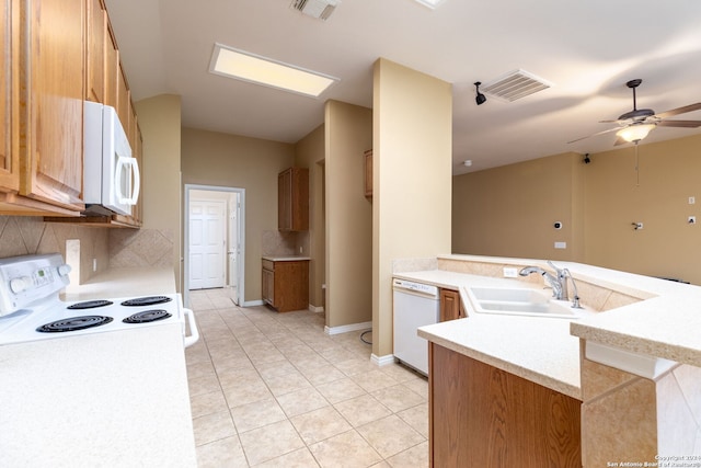 kitchen with kitchen peninsula, ceiling fan, sink, and white appliances