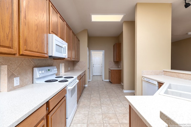 kitchen featuring white appliances, backsplash, and light tile patterned floors