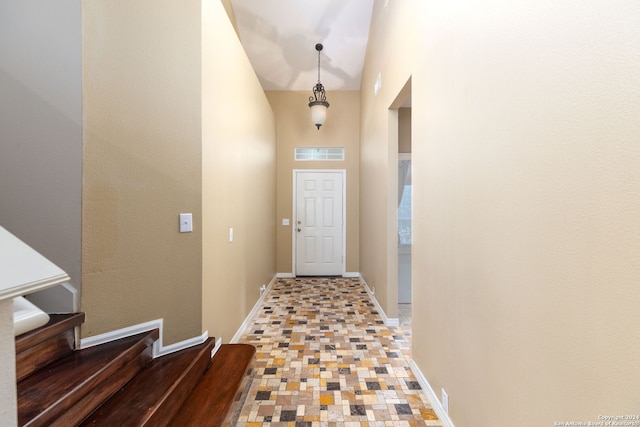 doorway to outside featuring high vaulted ceiling