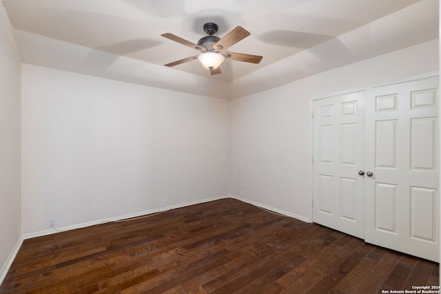 unfurnished room with ceiling fan and dark wood-type flooring