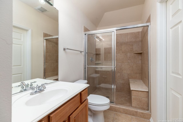 bathroom featuring tile patterned floors, a shower with door, vanity, and toilet