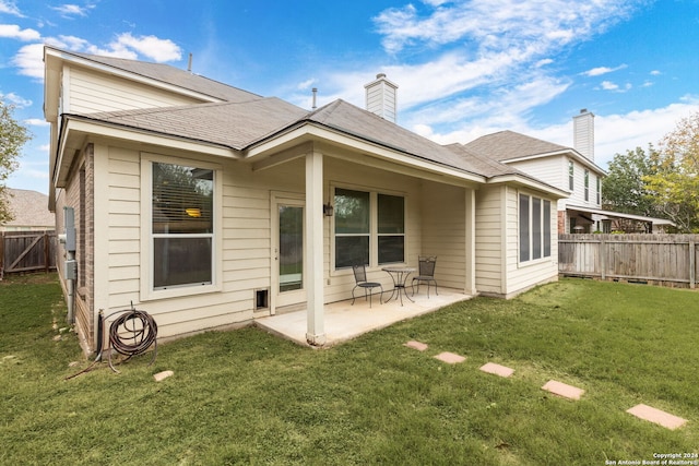 rear view of property featuring a patio area and a lawn