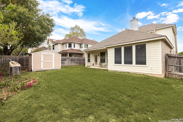 back of house featuring a patio area, a yard, and a storage unit