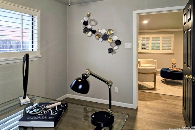 workout area with hardwood / wood-style floors and crown molding