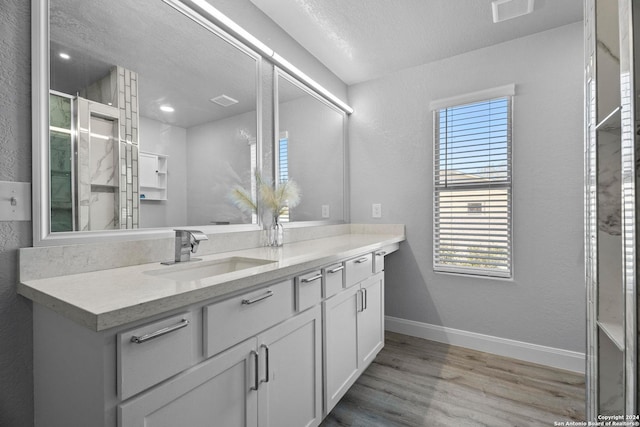 bathroom with hardwood / wood-style flooring, plenty of natural light, a textured ceiling, and vanity