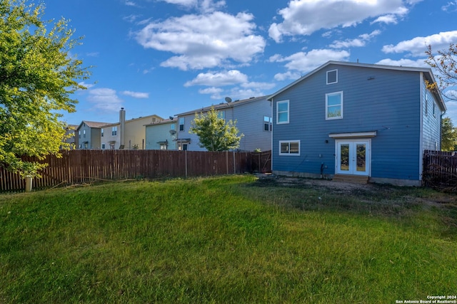 rear view of property featuring a yard and french doors