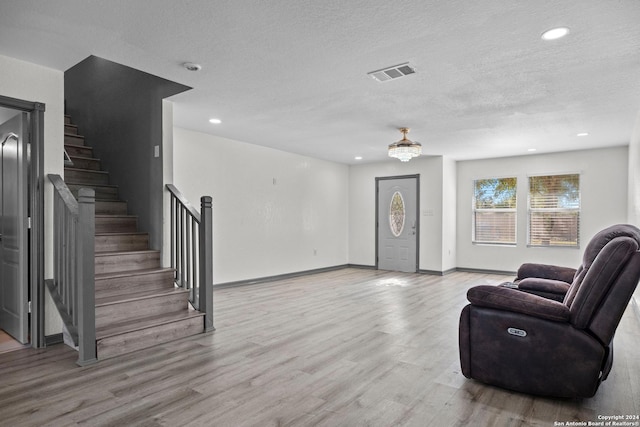 living room with light wood-type flooring and a textured ceiling