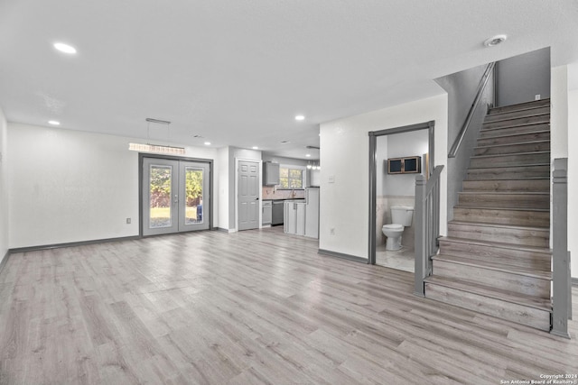 unfurnished living room featuring light hardwood / wood-style flooring and french doors