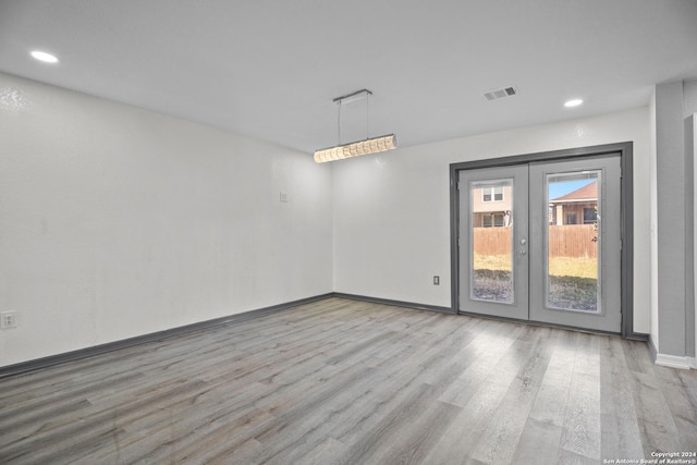 spare room featuring light hardwood / wood-style flooring and french doors