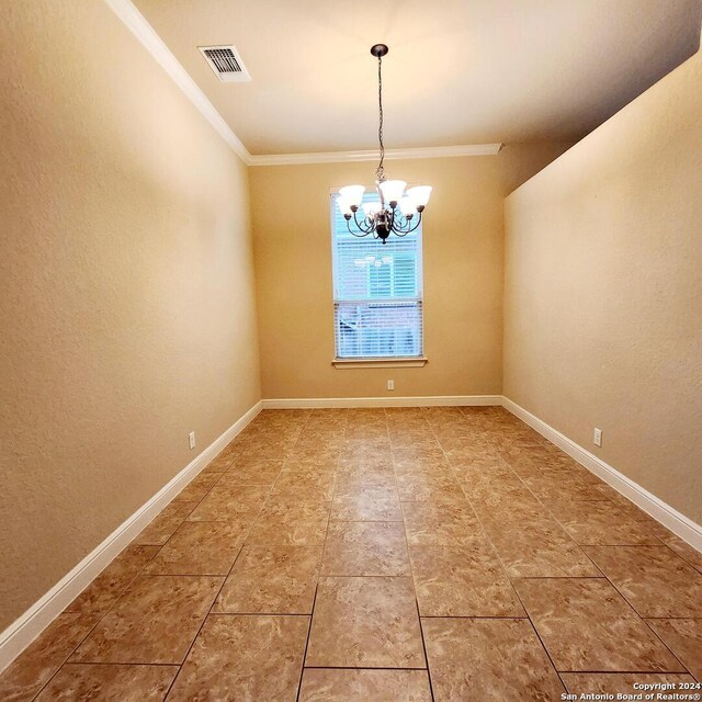 spare room featuring ornamental molding and a notable chandelier