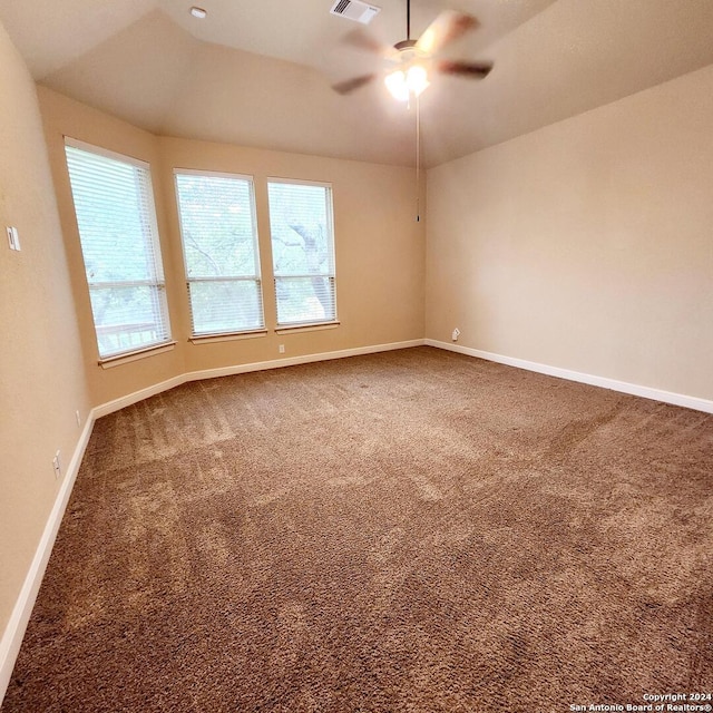 unfurnished room with ceiling fan and carpet