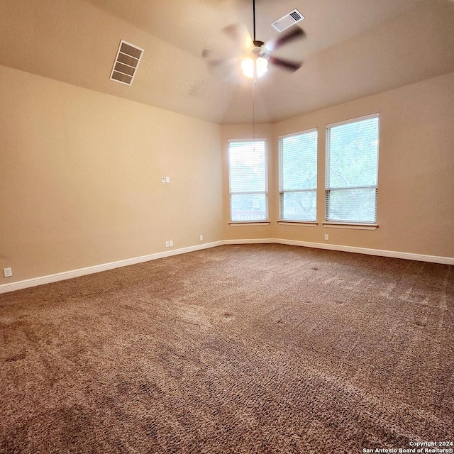 carpeted empty room with ceiling fan and vaulted ceiling