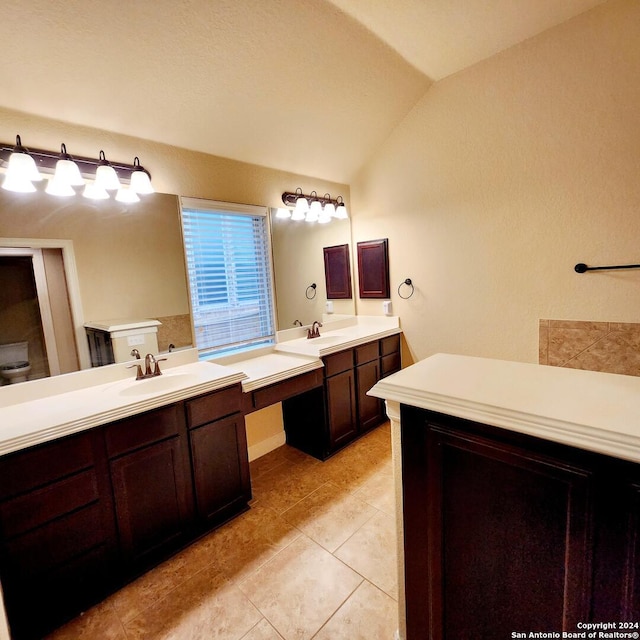 bathroom featuring tile patterned floors, vanity, and vaulted ceiling