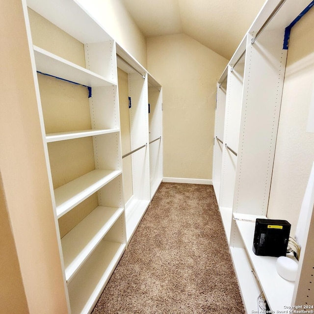 spacious closet featuring carpet flooring and lofted ceiling