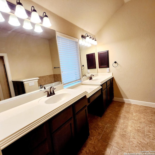 bathroom with a tub to relax in, vanity, and lofted ceiling