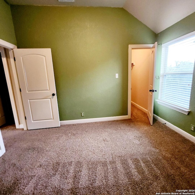 spare room featuring lofted ceiling and carpet floors