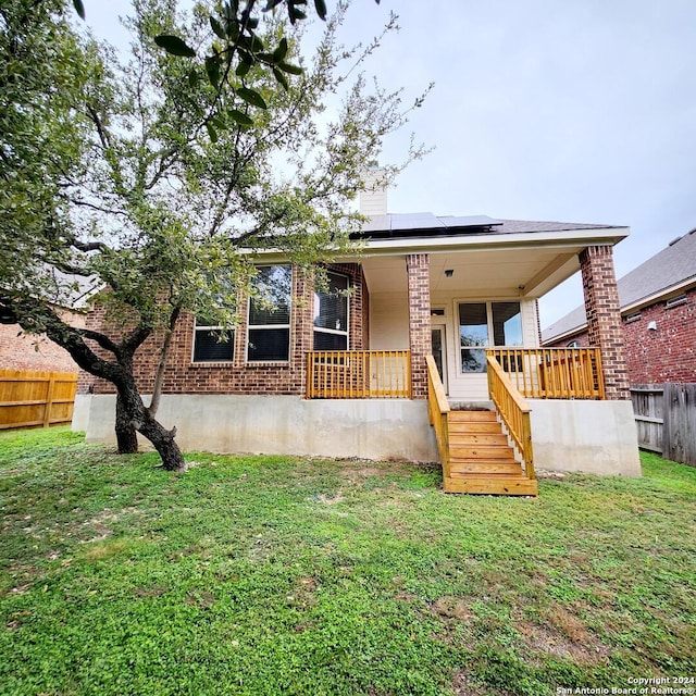 view of front facade with solar panels and a front lawn