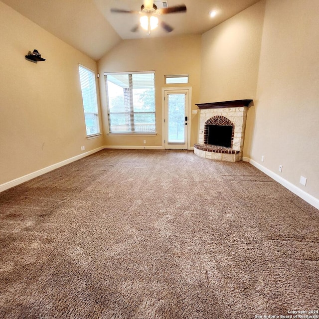 unfurnished living room featuring carpet flooring, ceiling fan, a fireplace, and vaulted ceiling