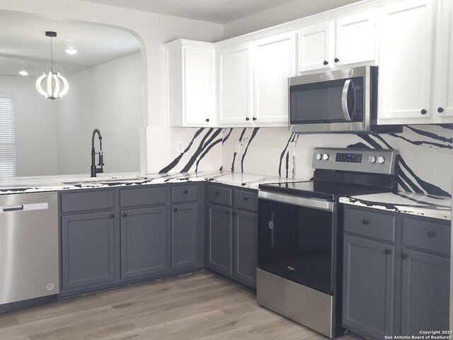 kitchen featuring white cabinets, appliances with stainless steel finishes, light hardwood / wood-style floors, and sink