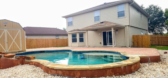 back of house featuring a fenced in pool and a storage shed