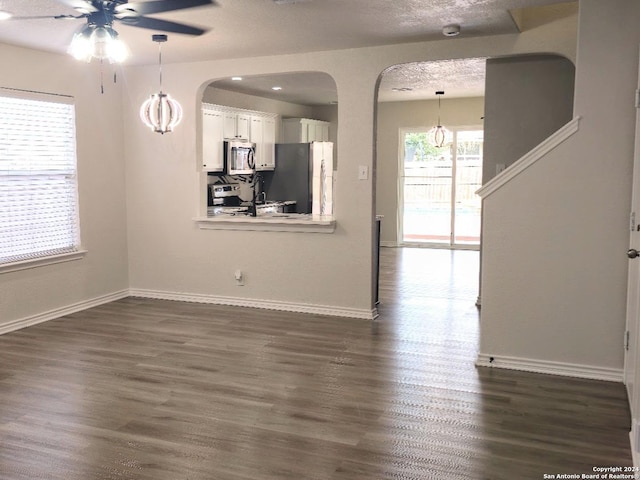 interior space featuring ceiling fan, dark hardwood / wood-style flooring, and a textured ceiling