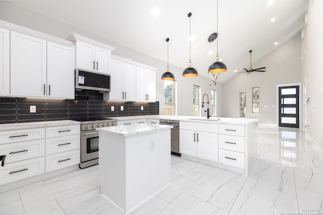 kitchen featuring kitchen peninsula, stainless steel appliances, ceiling fan, decorative light fixtures, and a center island