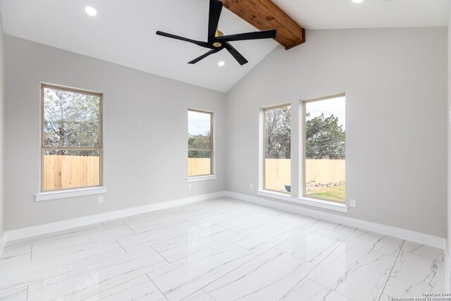 spare room with a wealth of natural light, ceiling fan, and lofted ceiling with beams