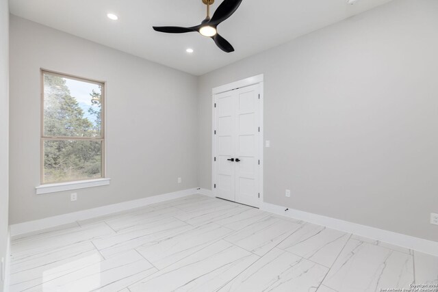 unfurnished bedroom featuring ceiling fan and a closet