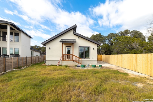 rear view of property with a yard