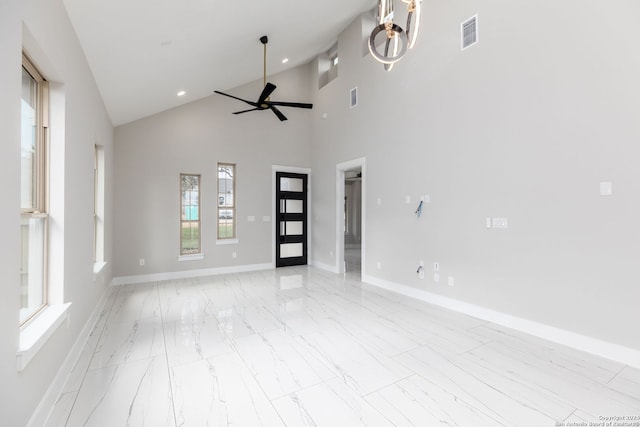 unfurnished living room with ceiling fan and high vaulted ceiling