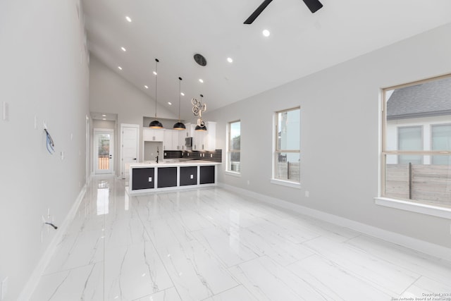 unfurnished living room with ceiling fan and high vaulted ceiling