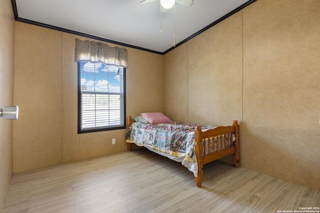 bedroom featuring light hardwood / wood-style flooring, ceiling fan, and crown molding