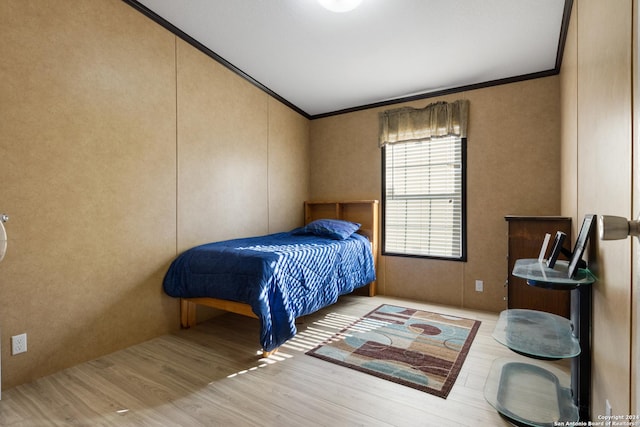 bedroom with light wood-type flooring and ornamental molding