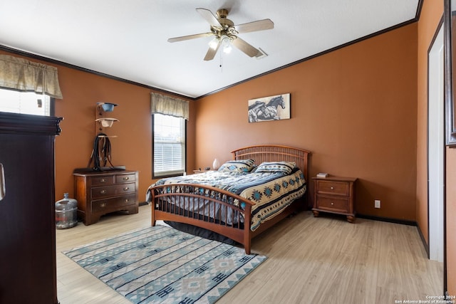 bedroom featuring light hardwood / wood-style floors, ceiling fan, and crown molding