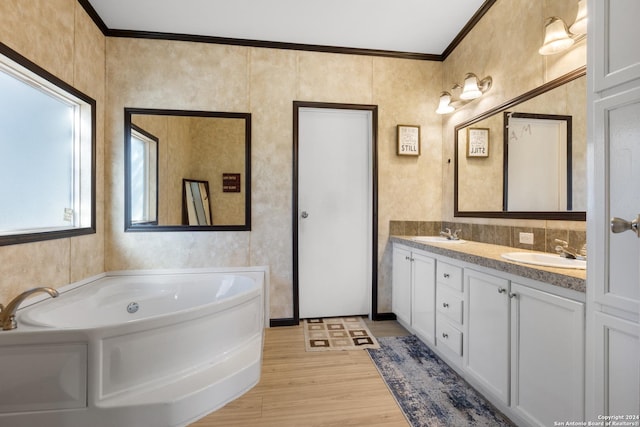 bathroom featuring a bathtub, wood-type flooring, crown molding, and vanity