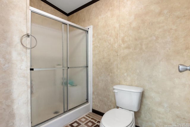 bathroom featuring toilet, walk in shower, and ornamental molding