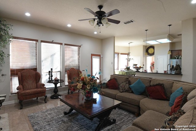 living room featuring light tile patterned floors and ceiling fan with notable chandelier