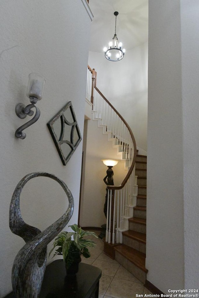 stairway with tile patterned flooring and a chandelier