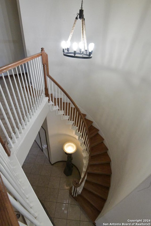 stairway featuring tile patterned flooring and a chandelier