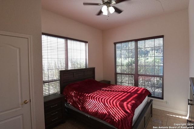 bedroom with ceiling fan and tile patterned flooring