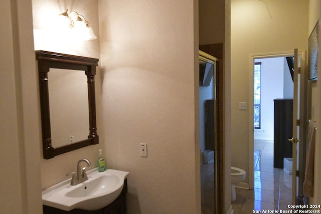 bathroom featuring tile patterned flooring, toilet, and sink