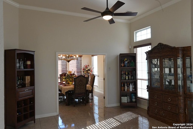 tiled dining room featuring ceiling fan with notable chandelier, a towering ceiling, and crown molding